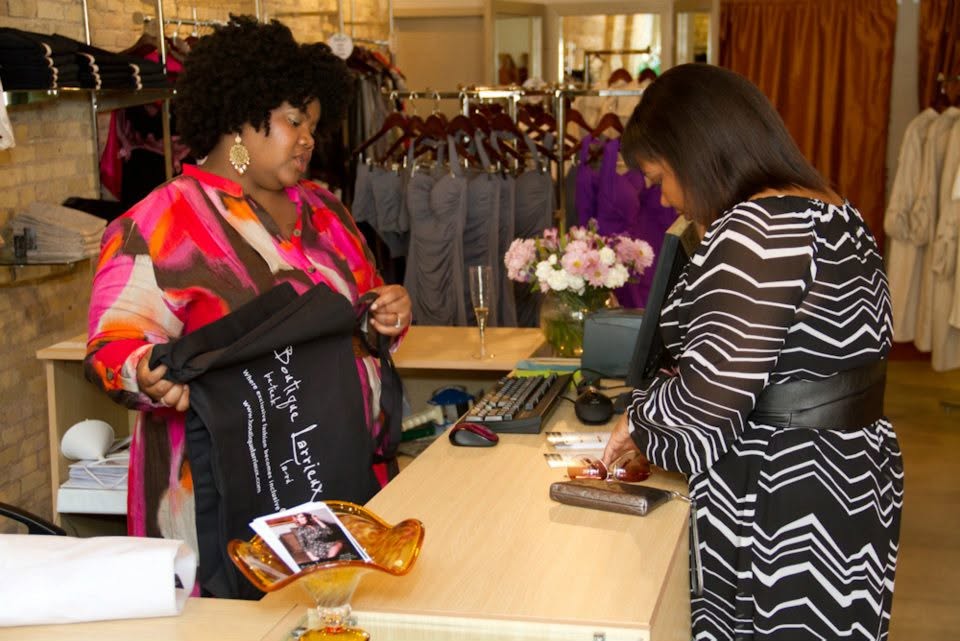 Lydia Hamilton working with a customer at the counter of her apparel boutique