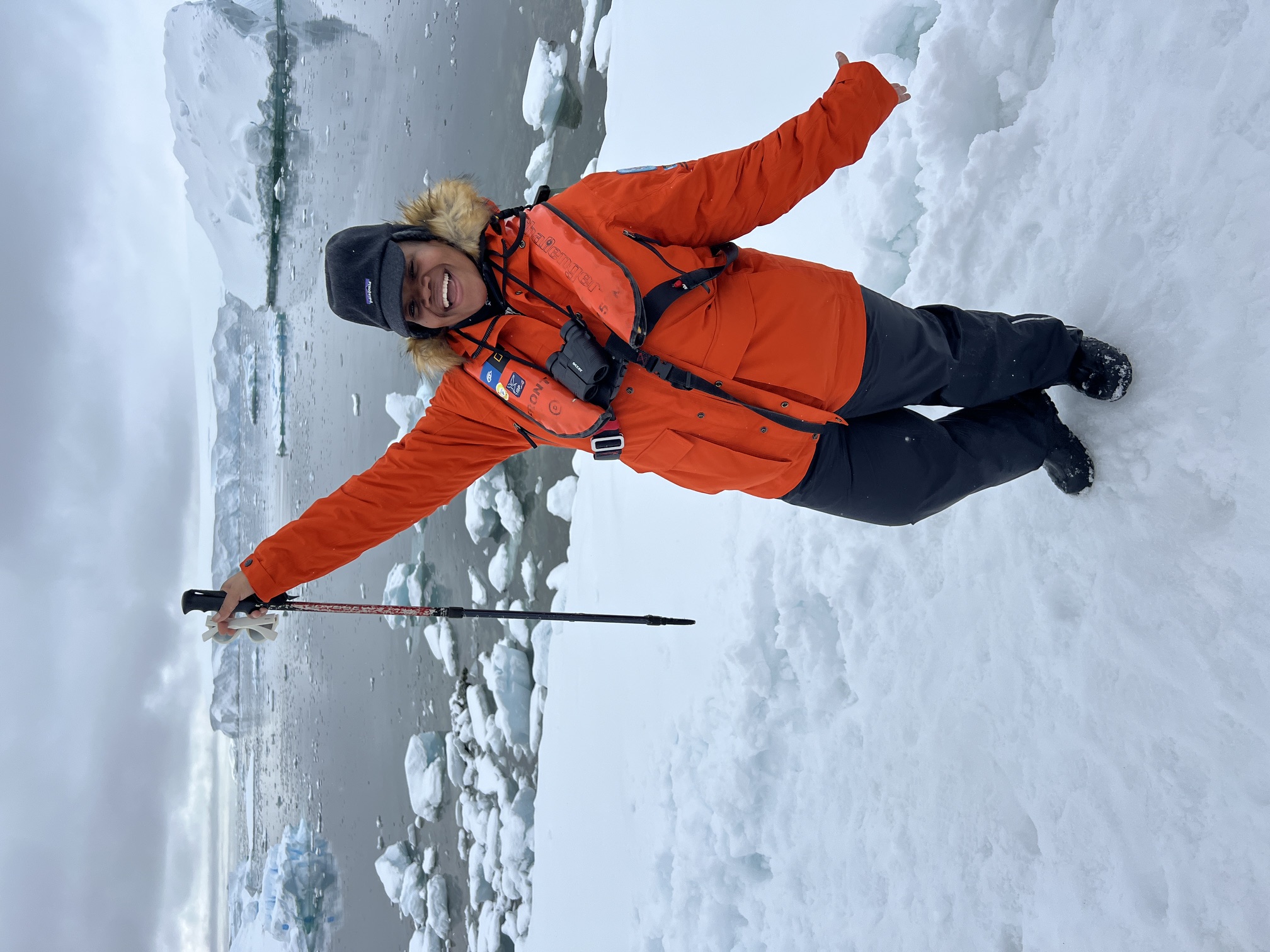 Lydia Hamilton celebrating in Antarctica surrounded by icebergs
